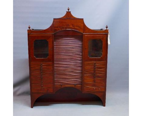 A Victorian mahogany medicine cabinet, with architectural pediment above 18 drawers having ceramic linings, two glazed doors,