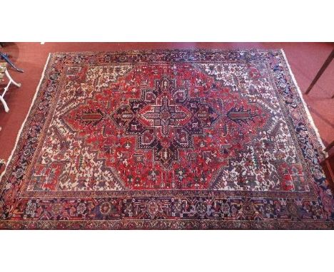 A Heriz carpet, with central geometric floral medallion, contained by many geometric borders, 330 x 246cm 