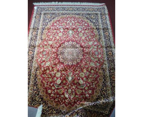 A Kashan style carpet, with central floral medallion, on a red ground, contained by floral borders, 230 x 160cm 