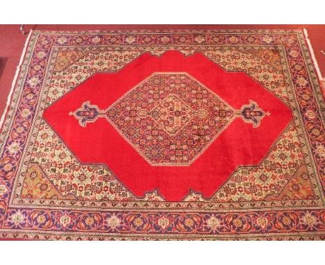 A fine North West Persian Tabriz carpet, central diamond medallion with repeating petal motifs in four corners on a rouge fie