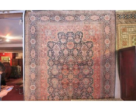 An extremely fine Indian pure silk carpet, having central floral motifs, on a dark blue ground, contained by floral borders, 