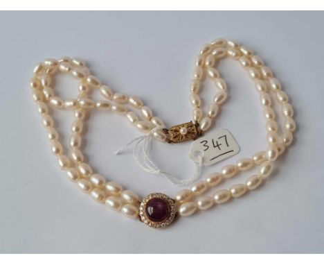 A good pearl necklace with attractive star ruby and diamond clasp 