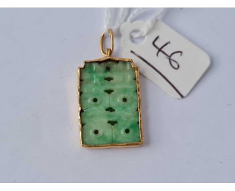 A vintage high carat gold pendant set with carved jade 