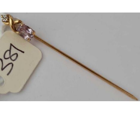 A amethyst and diamond fancy stick pin set in gold