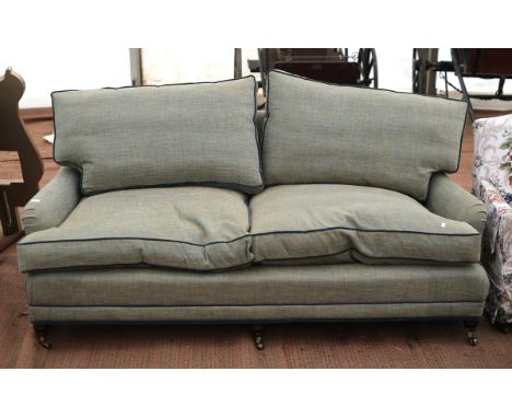 Howard & Son style three seat sofa, by Whitehead (Grosvenor), in green blue upholstery, on turned legs and brass castors, mod