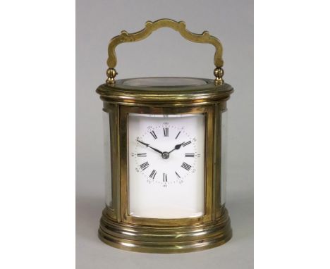 An oval brass cased carriage clock, 20th century, the white enamel dial with Roman and Arabic numerals, striking on a gong, s