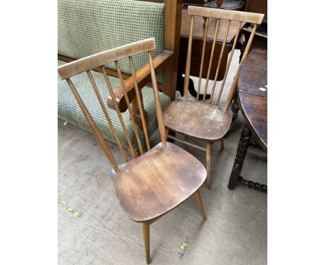 A pair of Ercol teak stick back dining chairs on tapering legs 