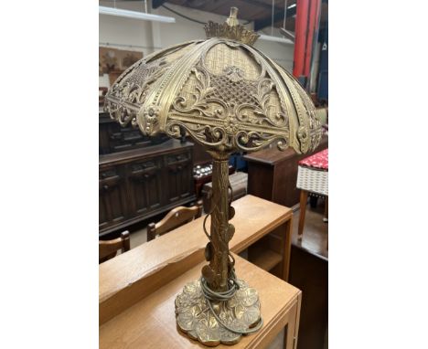 A brass table lamp with a lily pad decorated column