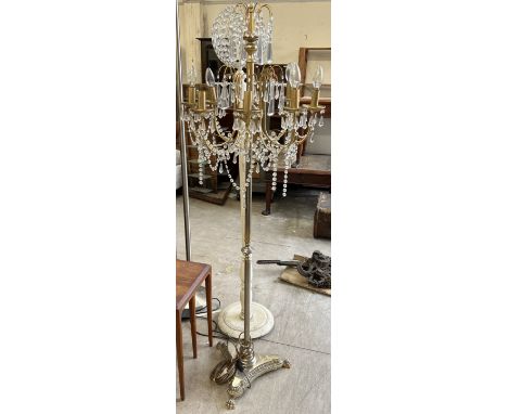 A brass chandelier standard lamp with eight arms and lustre drops
