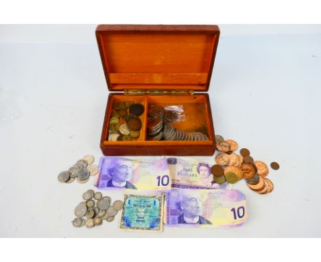 A vintage cigar box with lid depicting an angel and blacksmiths containing a quantity of coins and banknotes to include 26 si