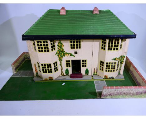 Tri-ang - A vintage wood and metal two storey six room dolls house with a walled garden base and sliding front facade. The pl