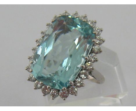 A 1960s 18 carat white gold, aquamarine and diamond dress ring, the large mixed cut stone 19.4 x 12.8mm, in a surround of 24 