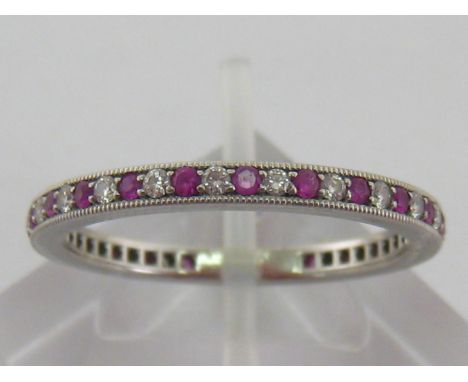 A Tiffany platinum, ruby and diamond eternity ring, signed to inner shank, 2mm width, finger size T, 4.6 gms, with original p