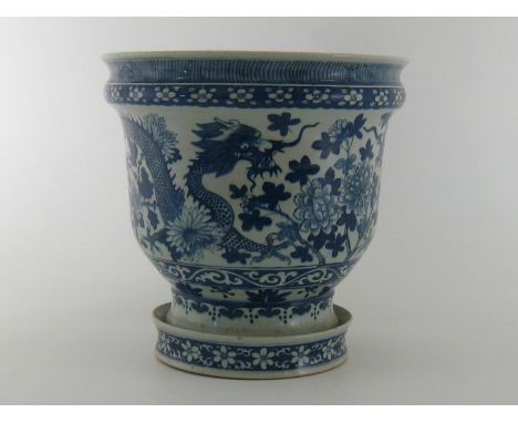 A late 19th. century  Chinese blue and white planter decorated with dragons and flowers, the matching saucer with bamboo. 36c
