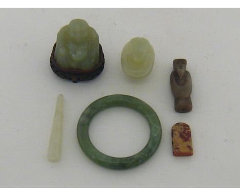 A hardwood box containing five green hardstone Chinese items including a Buddha on hardwood stand, a bangle, a frog covered b