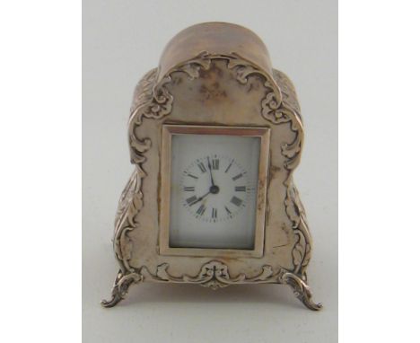 A late Victorian silver boudoir clock , the French balance wheel movement with white enamel face and bevelled glass in ornate