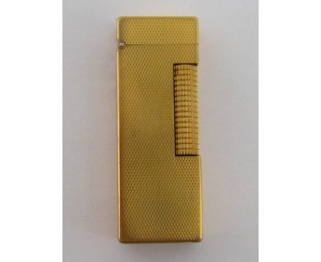 A gold plated Dunhill lighter, with engine turned finish, 64mm long
 CONDITION REPORT: wear through use, plating on the corne