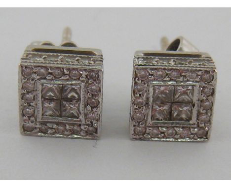 A pair of Art Deco 18 carat white gold and diamond ear studs, the box setting pavé set with four table cuts to the centre in 