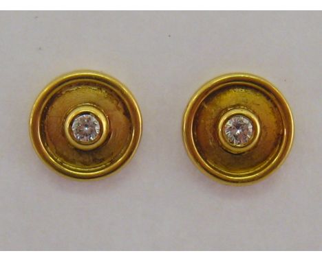 A pair of 18 carat yellow gold and diamond ear studs, the disc studs with a central brilliant approx. 0.06 carat, hallmarked 