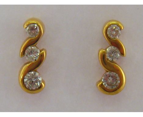 A pair of 18 carat yellow gold and three stone diamond ear studs, the three graduated brilliants totalling approx. .28 carat,