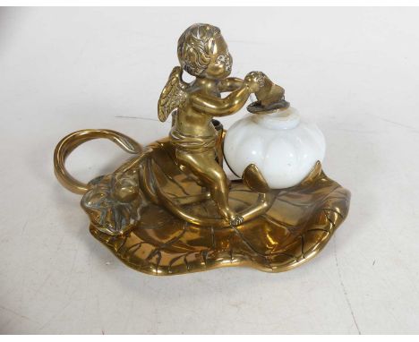 A Victorian brass inkwell, in the manner of William Tonks &amp; Sons, in the form of a lily pad, surmounted by a cherub, havi