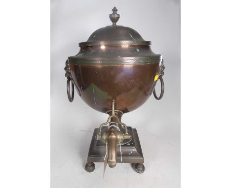 A 19th century copper samovar, the cover surmounted by an urn shaped finial, flanked by lion mask ring handles, standing on f