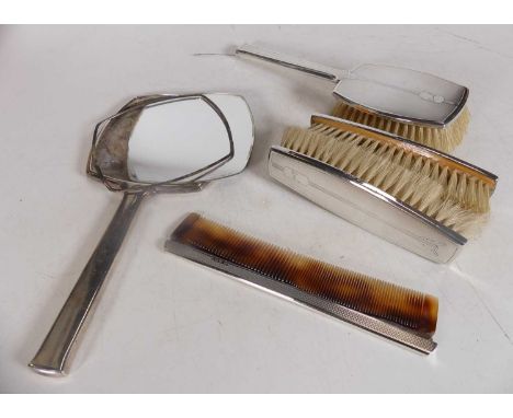An Art Deco style silver backed four piece dressing table set, to include hair brush, hand mirror, two clothes brushes, and c
