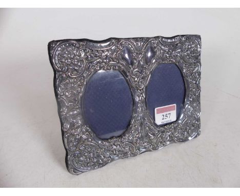 A modern silver clad easel photo frame, in the Art Nouveau style, repoussee decorated with flowers and scrolls, 14x18cm