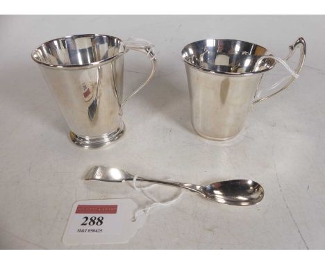 A George V silver christening mug of plain undecorated tapered cylindrical form, together with one other similar example and 