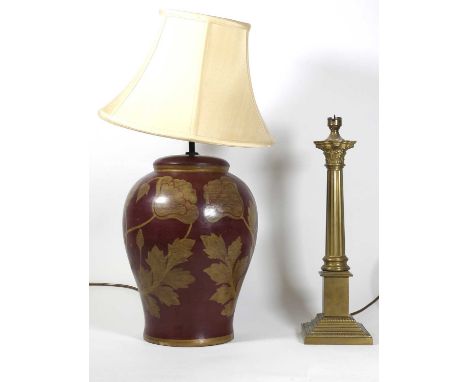 A contemporary composite table lamp, of baluster form, decorated in faded gilt with a foliate design on a red ground, h.36cm 