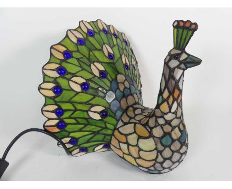 A contemporary Tiffany style stained glass table lamp in the form of a peacock, height 27cm