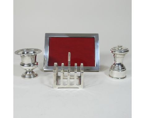 A silver photograph frame, 11 x 16cm overall, together with a small silver toast rack, pepper grinder and American silver min