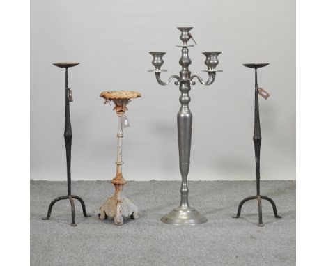 A 19th century cast iron candlestick, 66cm high, together with a pair wrought iron candlesticks and a floor standing candelab