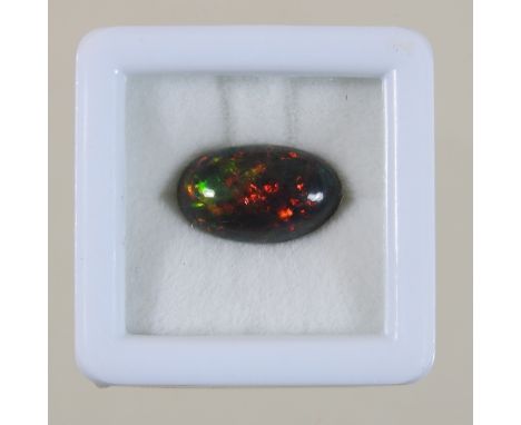 An unmounted black opal cabochon, 3.22 carats, with certificate