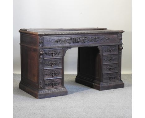 A 19th century heavily carved oak pedestal desk, 150cm