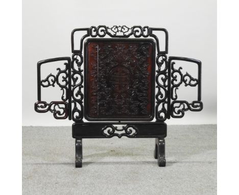 A Chinese carved rosewood fire screen, with an adjustable panel, 94cm wide