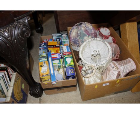 Two boxes containing various light shades and light bulbs