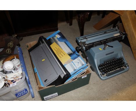 An Imperial 70 typewriter and a box containing Oxo tins, guillotine etc.