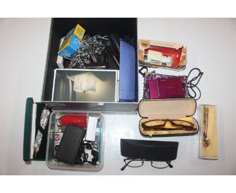 A box of sundry items to include Fuji Film digital camera, Dictaphone, pens, cigarette lighter etc.