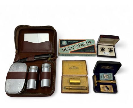 A vintage men's travelling grooming kit, with a vintage boxed Rolls razor and two cased Gillette Razors, and a pair of silver