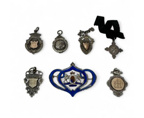 Five silver sporting medals, some with applied gold, a silver St Johns Ambulance medal, and a silver and blue enamel pin broo