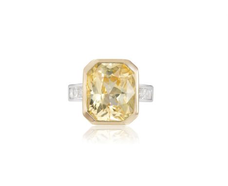 A FINE YELLOW SAPPHIRE AND DIAMOND RINGThe rectangular cut-cornered yellow sapphire, weighing 12.67cts, within collet setting