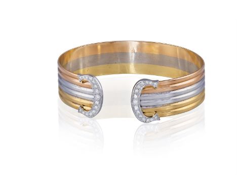 A DIAMOND 'DOUBLE-C' BANGLE, BY CARTIERDesigned as a tri-coloured gold bangle with brilliant-cut diamond 'C' terminals, in 18