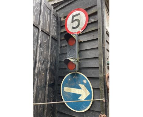 A Forrest City Manchester traffic light and two direction signs.