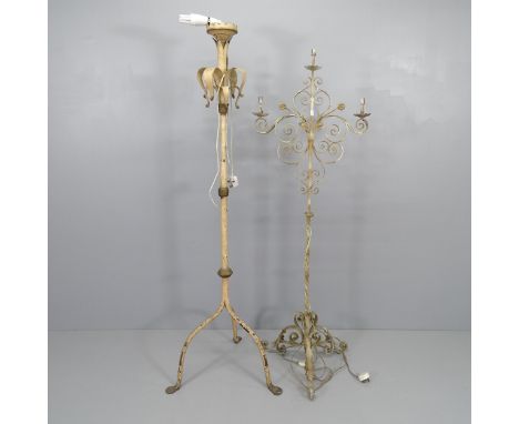 A wrought iron candelabra on tripod base, converted to electric. Height overall 158cm, and a vintage cast iron standard lamp,