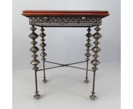 An unusual design side or lamp table, with the mahogany top on ornate base with beaten metal bobbin legs. 65x74x42cm