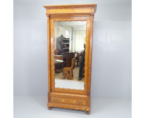 A French pitch pine armoire with single mirrored door, shelf fitted interior and single drawer under. 