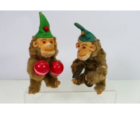 Max Carl - Two vintage, probably West German wind up animated monkeys attributed to Max Carl. The monkeys, one with symbols a