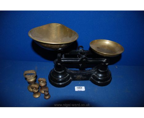 A cast Liltasco Weighing Scales with four weights of 1lb, 8oz, 4oz and 2oz.