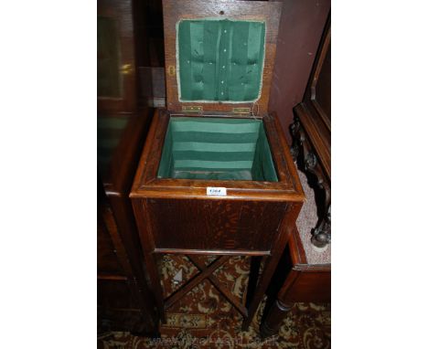 A 1920's Oak Sewing Box on stand having a moulded edge lifting lid with four Oak panels in moulded surround, plain single pan
